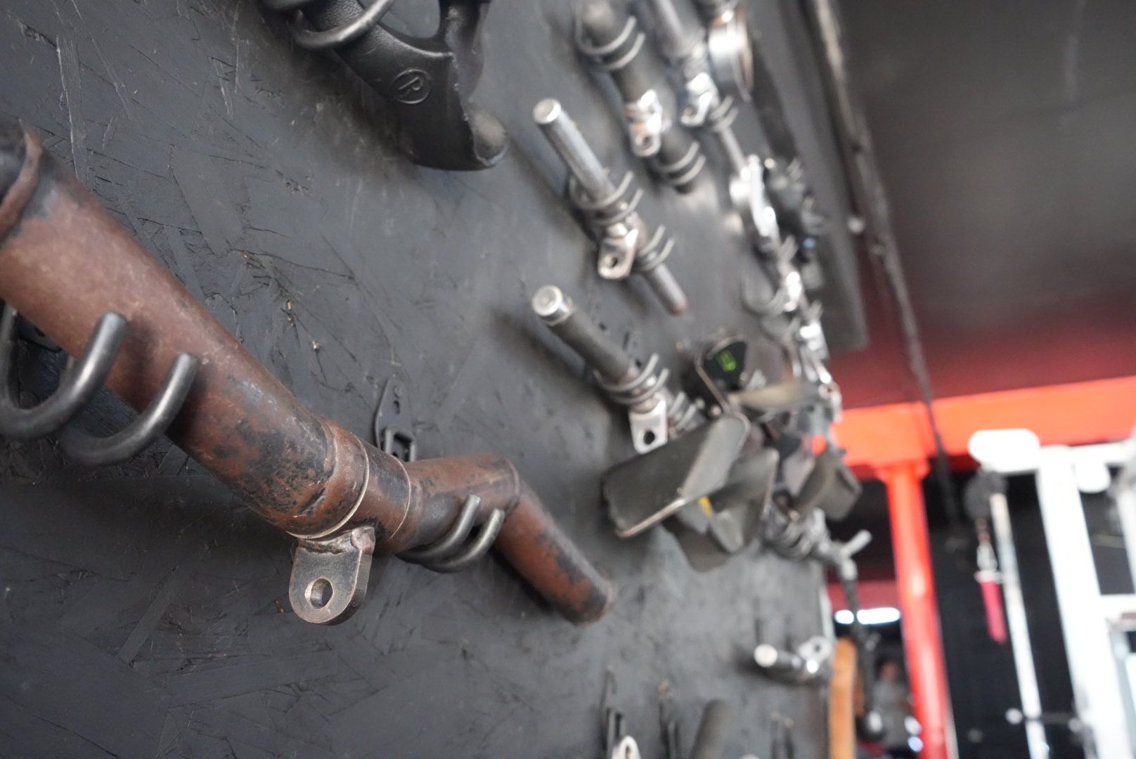 Close-up of industrial metal pipes and valves on a dark wall in a factory setting