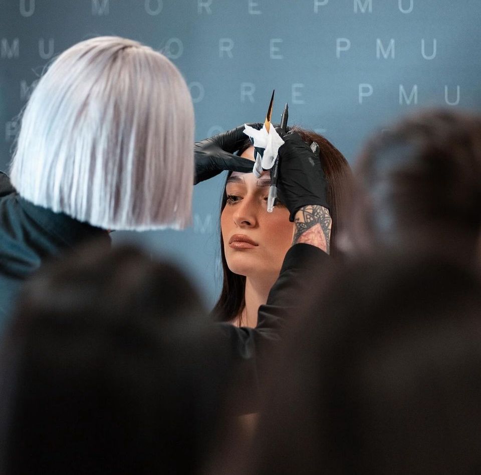 Una persona si tinge i capelli in un salone, vista da dietro una parrucchiera dai capelli bianchi.