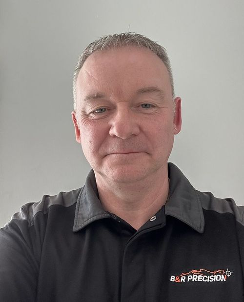 Sean Bolger is wearing a black shirt with the word precision on it.