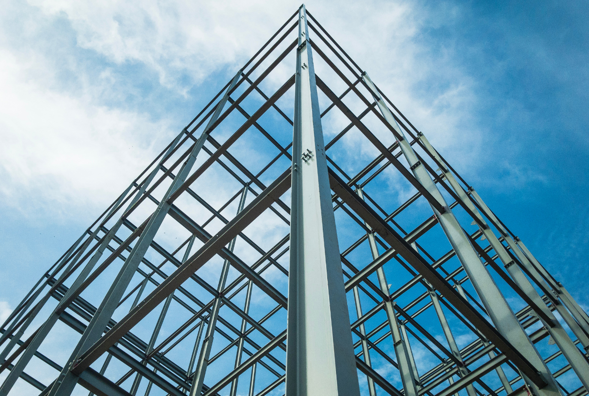 Steel skeleton of a building against a cloudy blue sky.