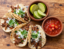 Overhead shot of street tacos with lime and salsa
