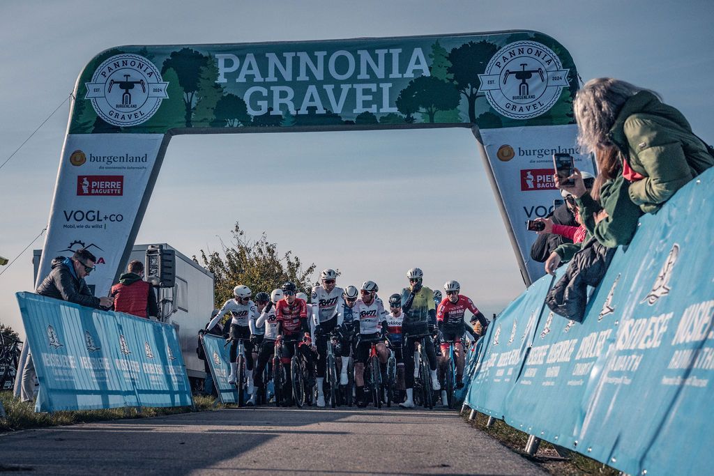 Die Radfahrer stellten sich unter einem Startbogen von Pannonia Gravel im Zielbereich eines Freiluftrennens auf.