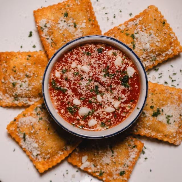 Quesadilla slices on a white plate with red salsa in a patterned bowl