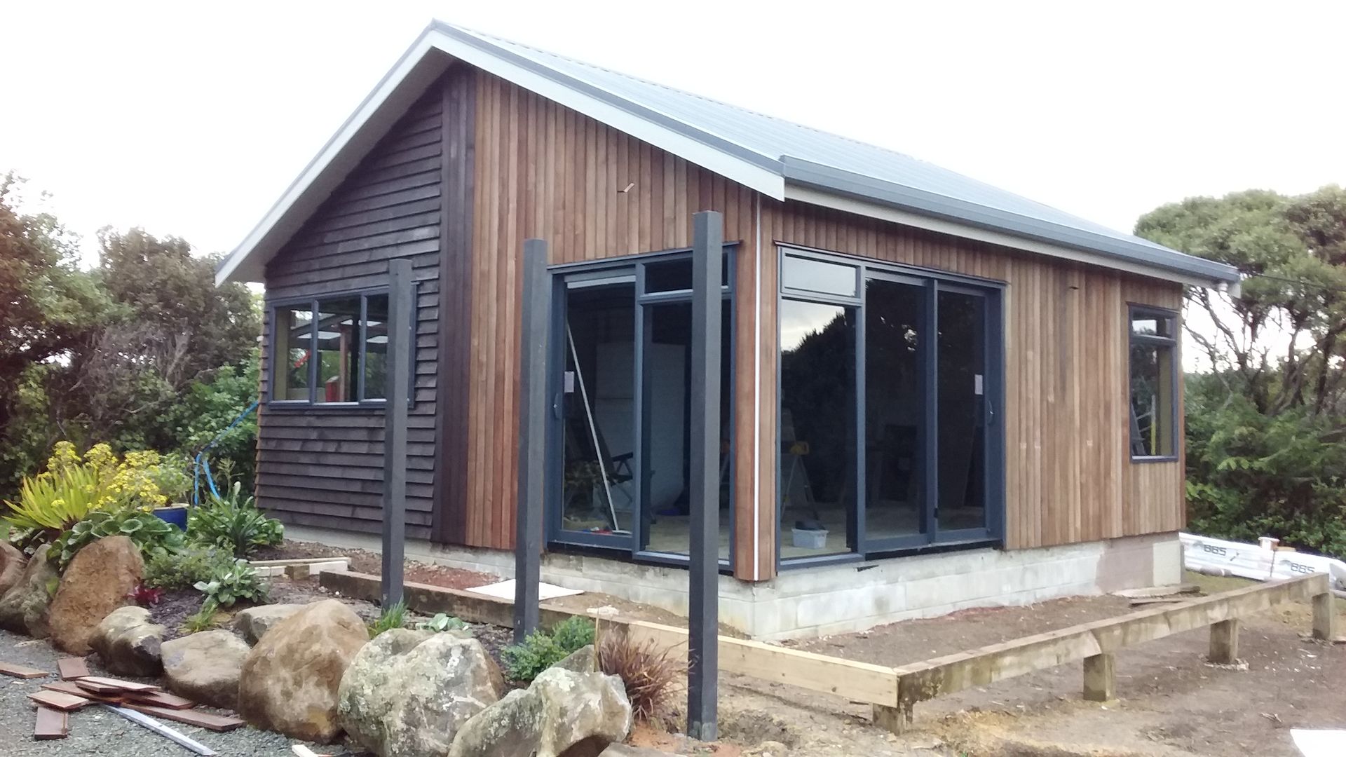 A small house with a lot of windows is being built.