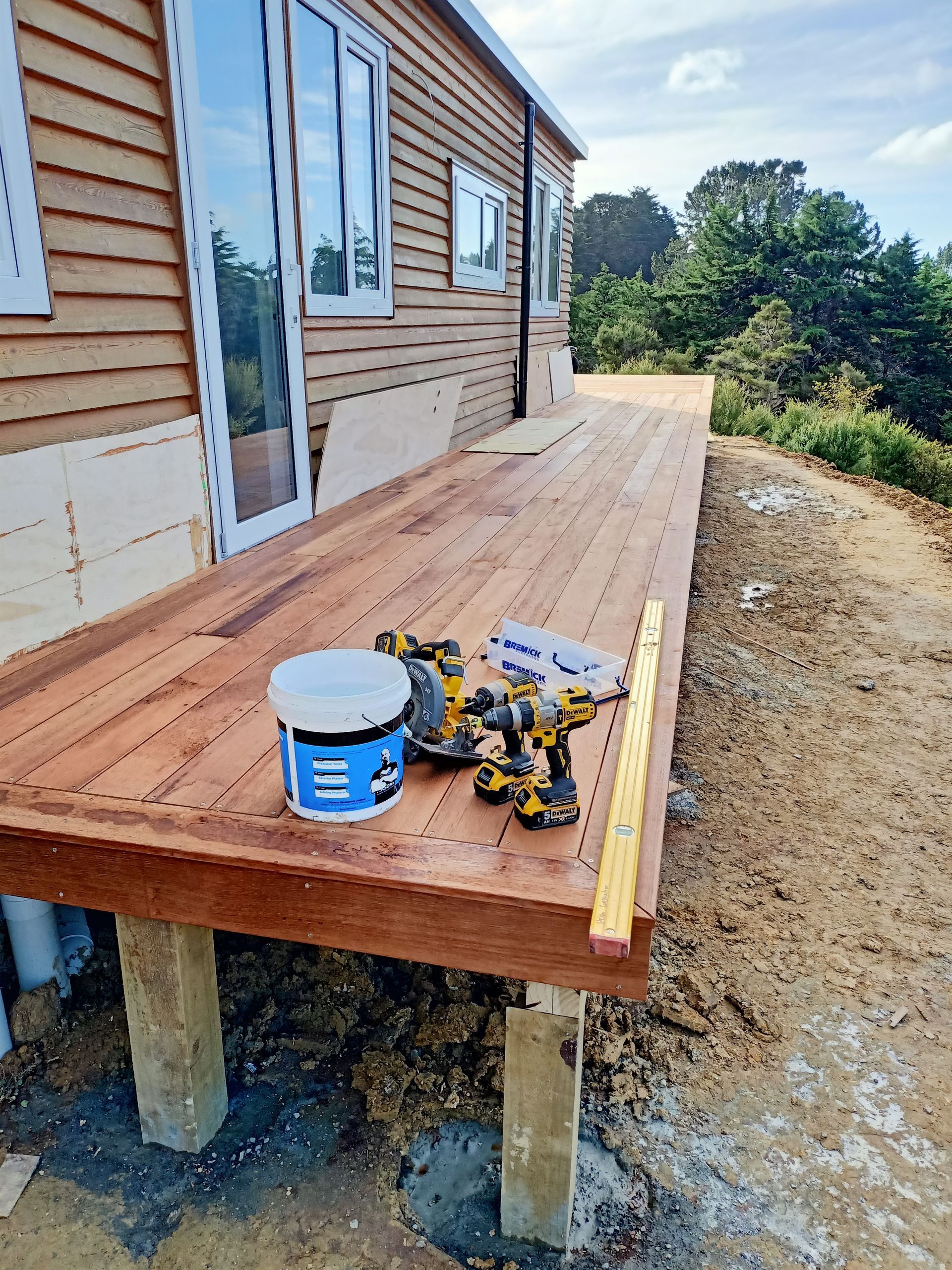 A wooden deck is being built in front of a house.