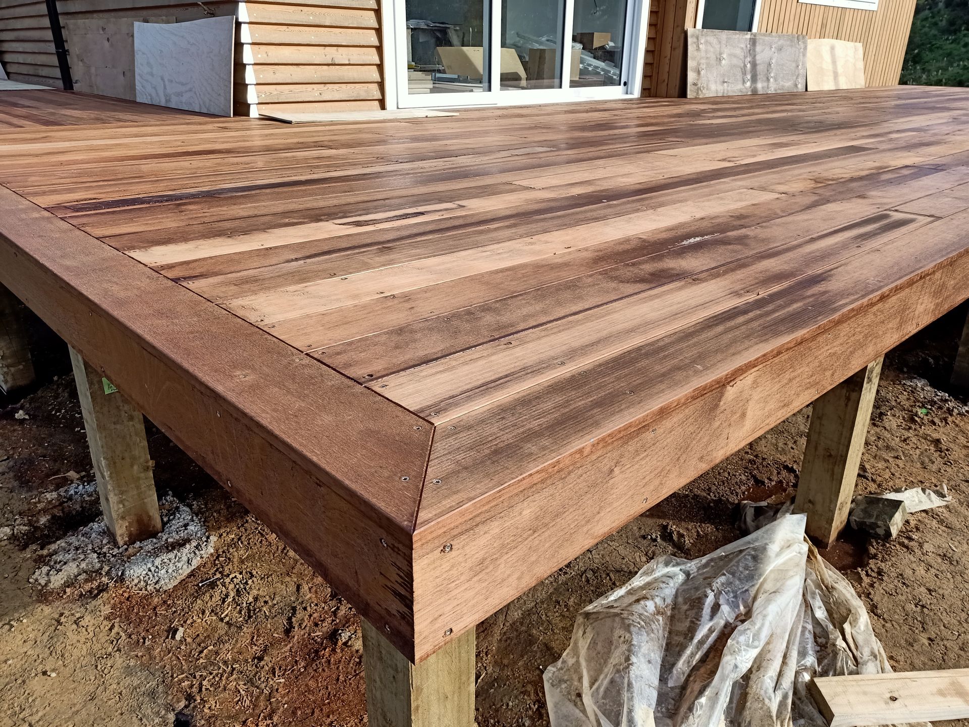 A wooden deck is being built in front of a house.