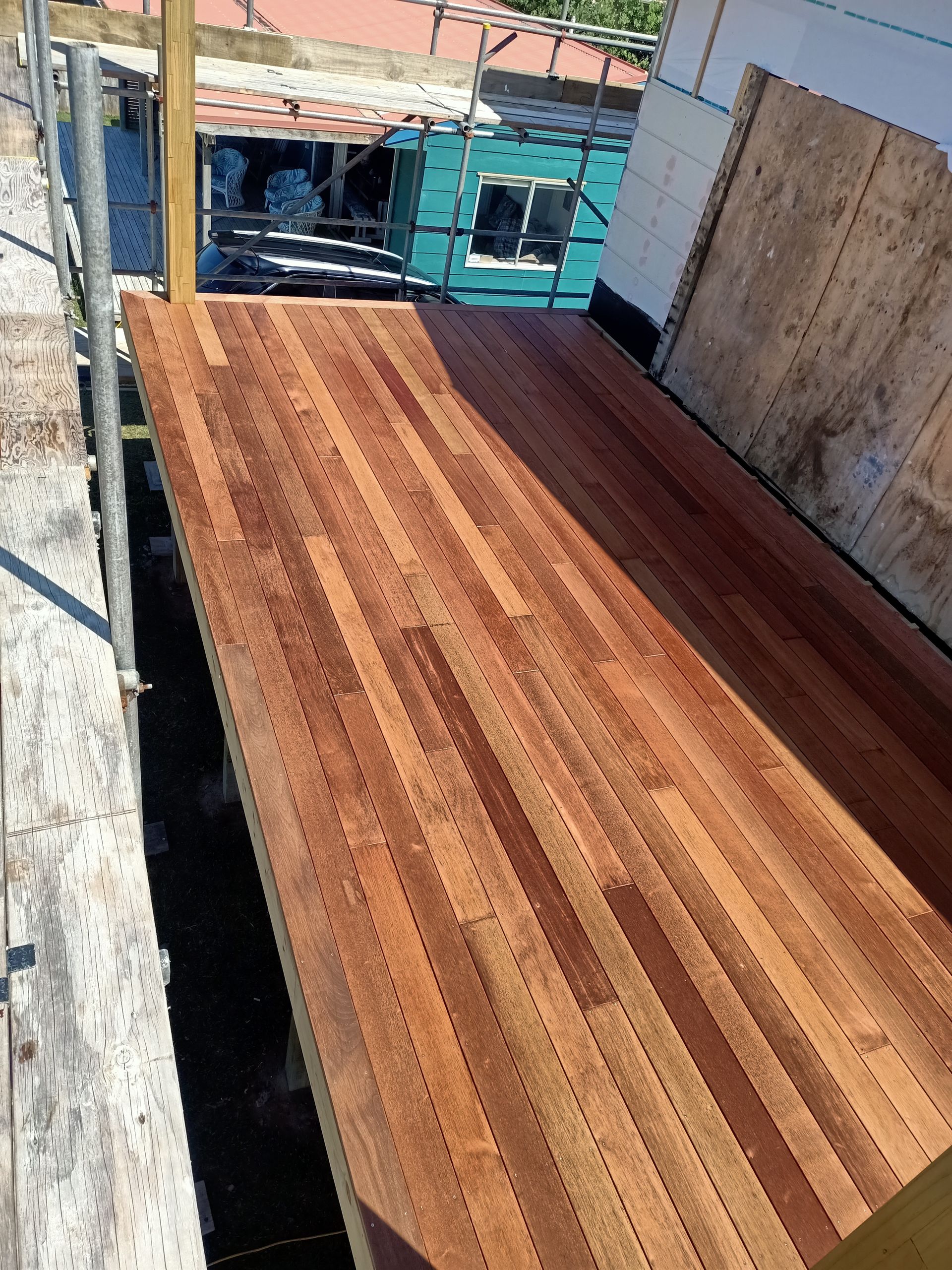 A wooden deck is being built on a scaffolding