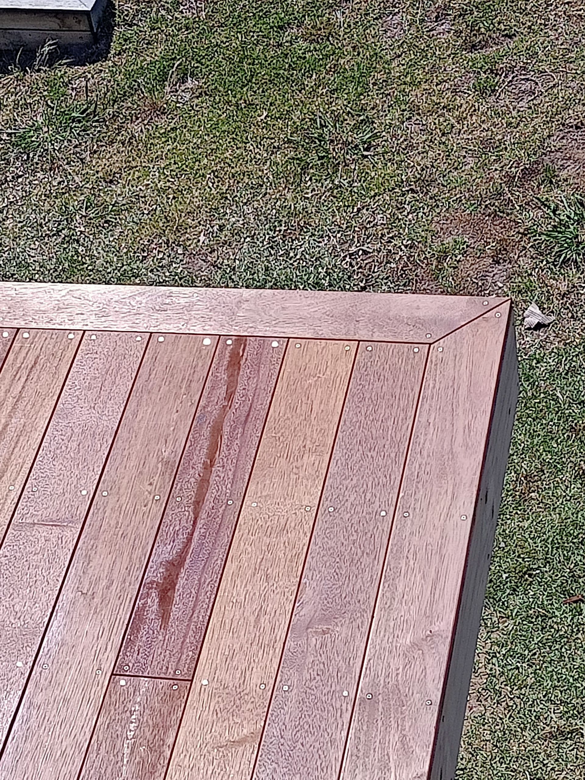A wooden deck is sitting on top of a lush green field.
