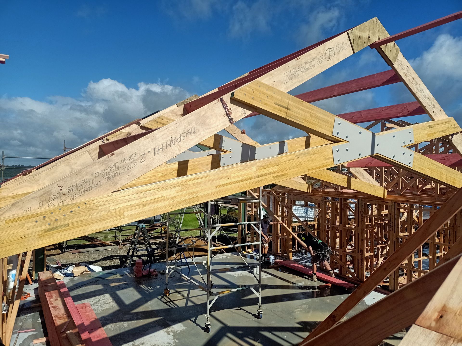A wooden structure is being built with a blue sky in the background.