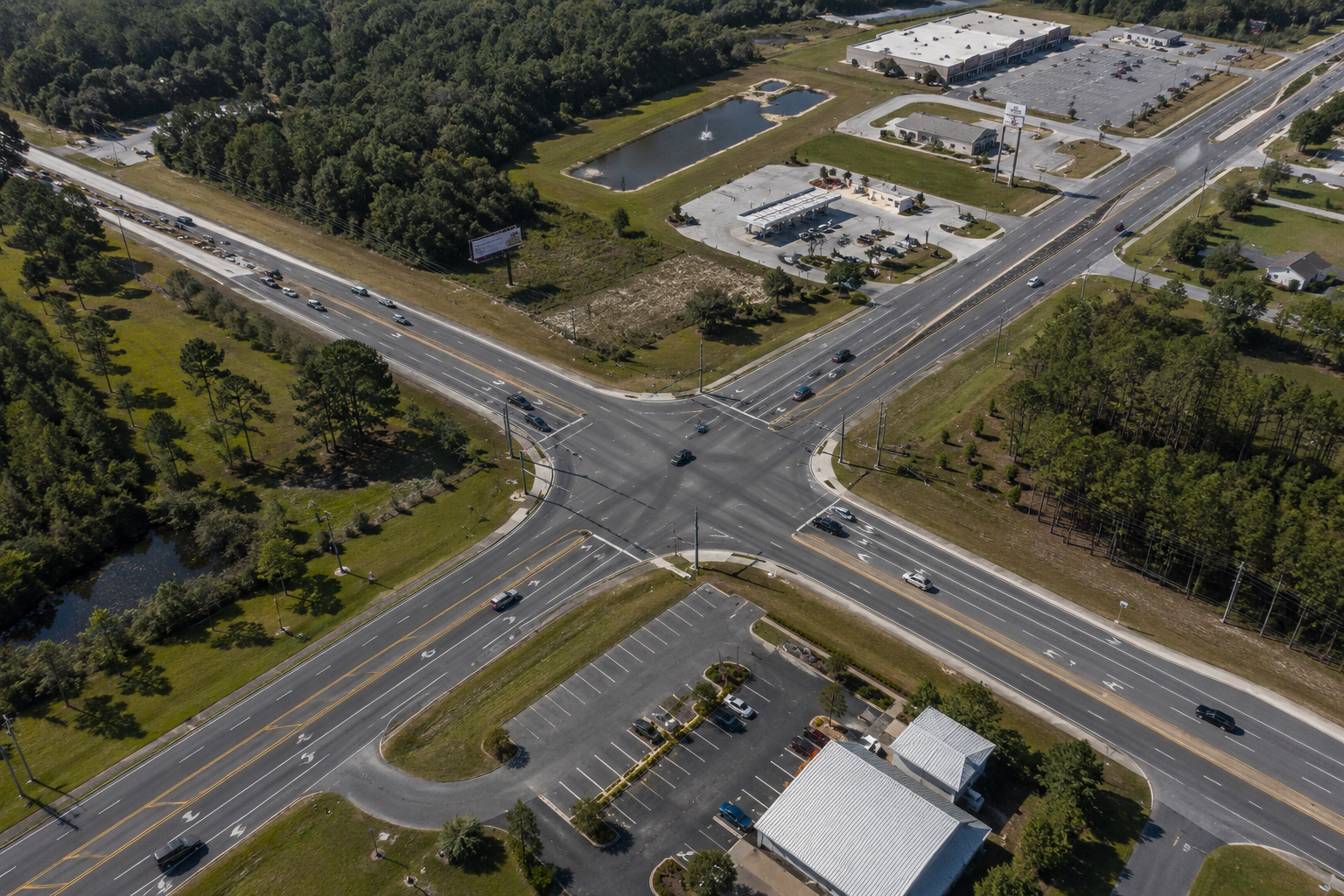 Aerial view of a multi-lane roadway intersection showing turn lanes, medians, traffic controls, and 
