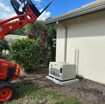 Red lift near a beige house, with a portable generator on a concrete pad beside the wall.