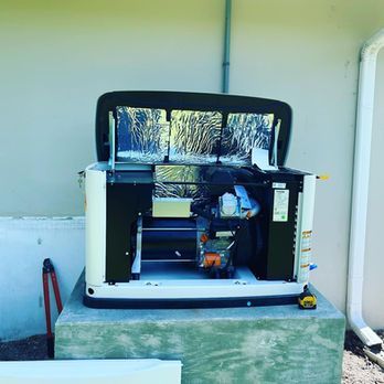 Open equipment cabinet with exposed wiring and components on a concrete platform outdoors