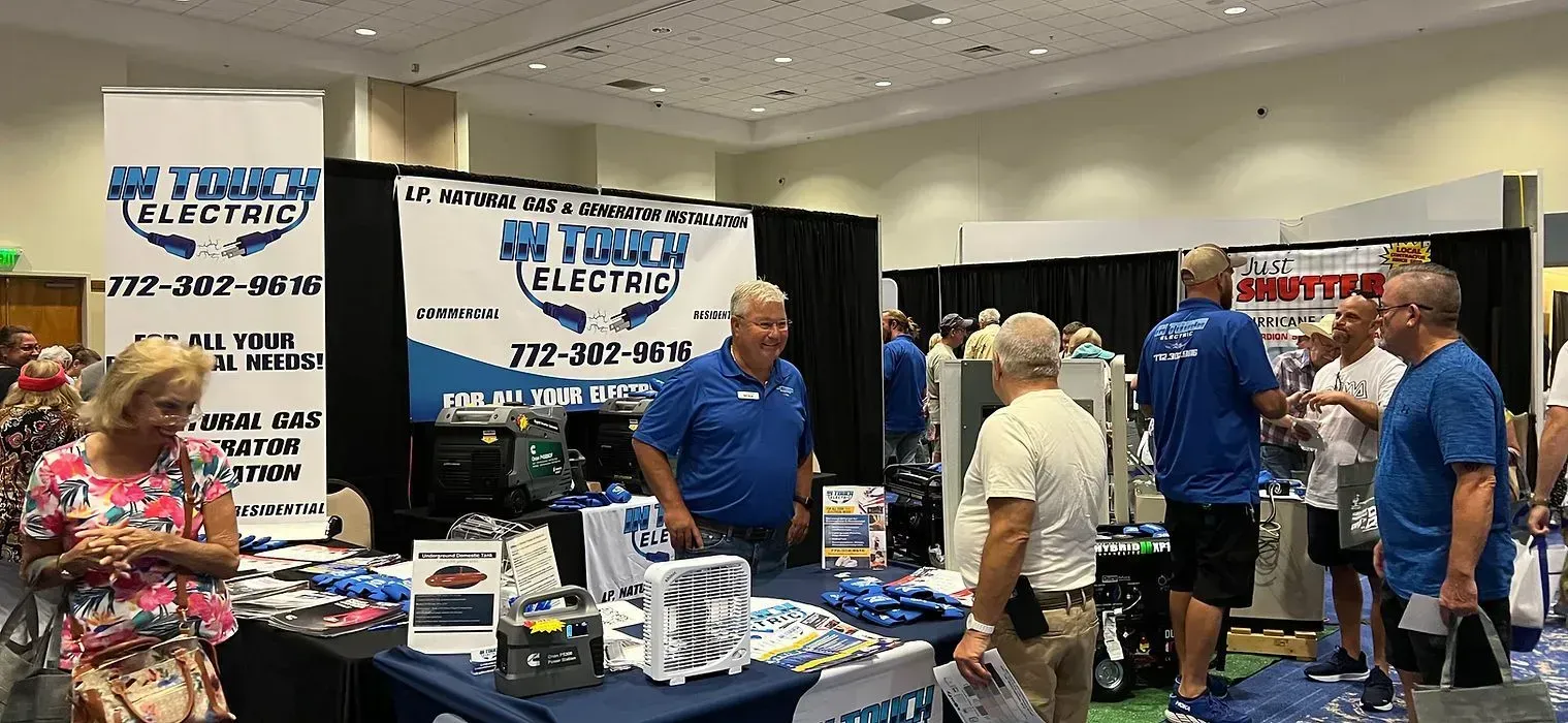 People browsing a blue-and-white vendor booth at a busy indoor trade show