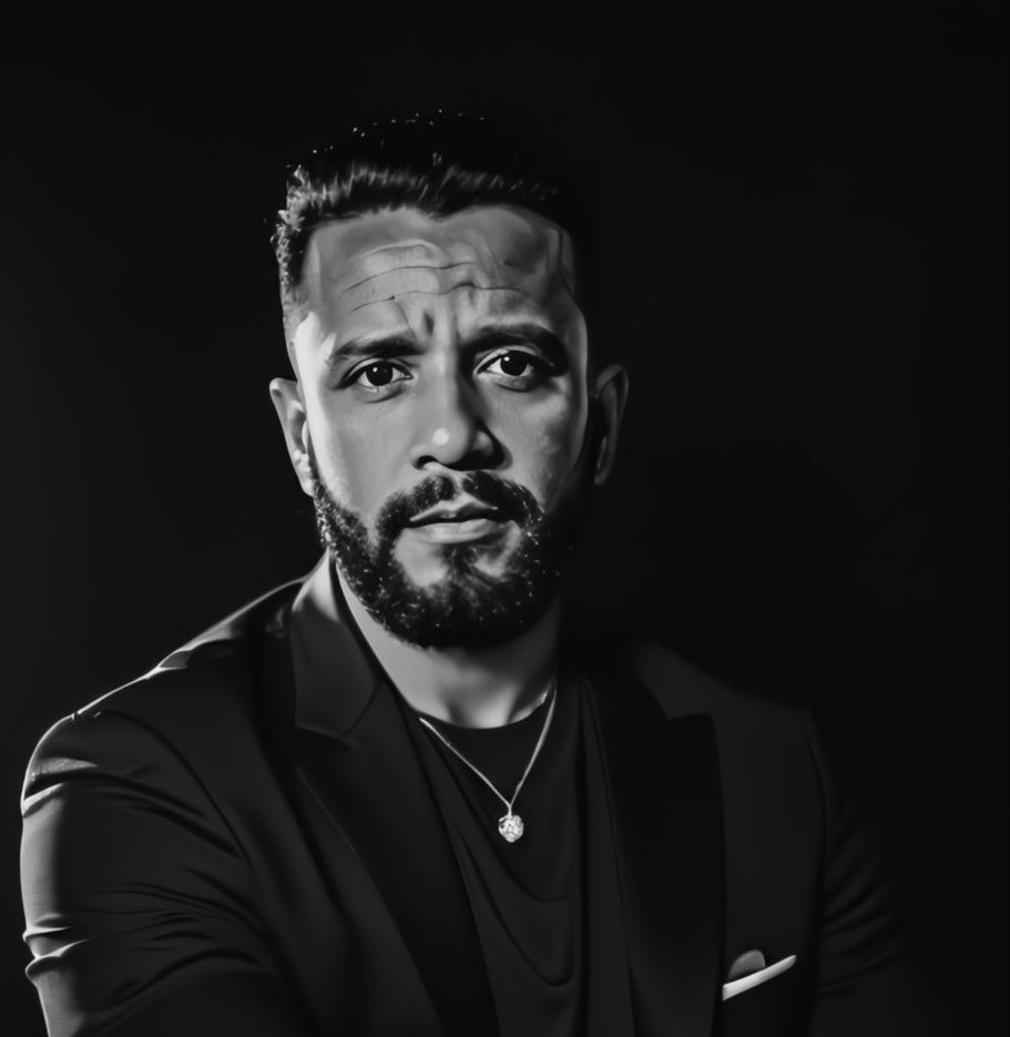 A man with a beard is wearing a suit and a necklace