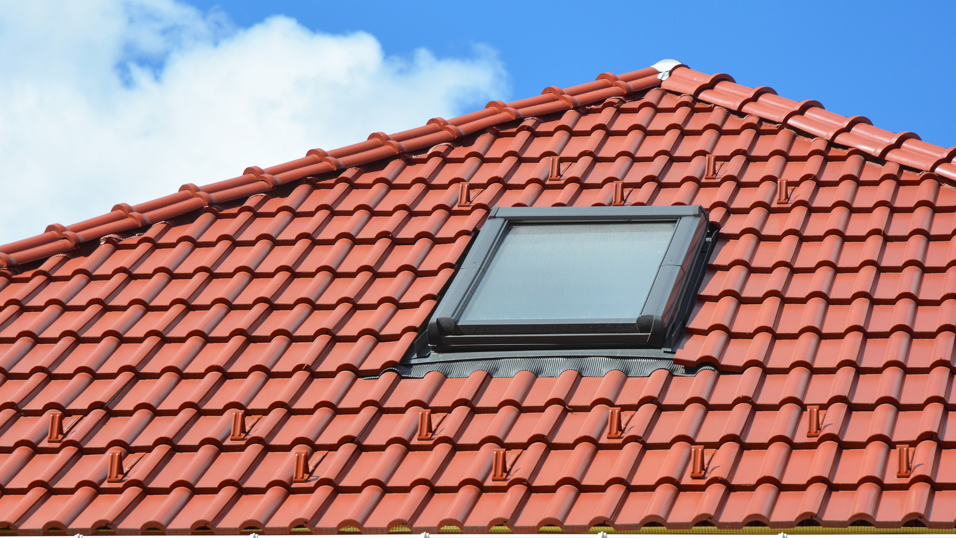 A red tiled roof with a skylight in the middle