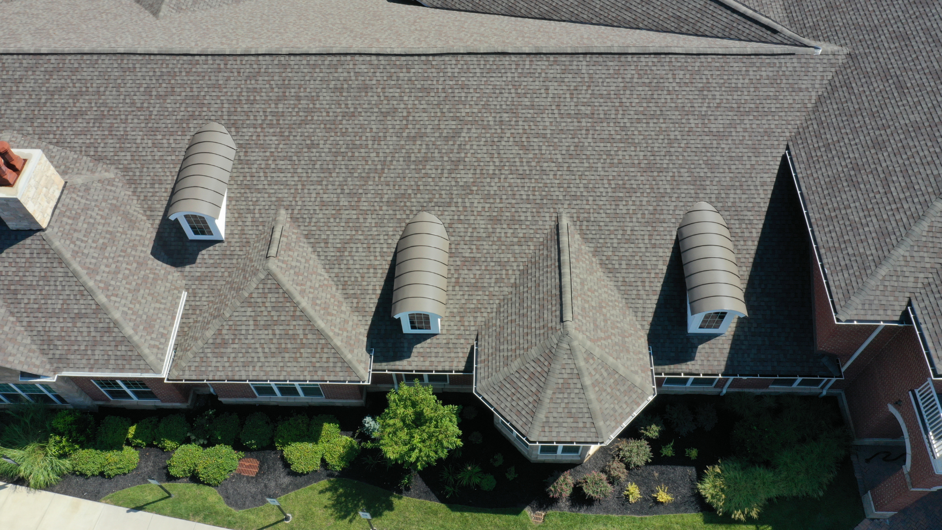 An aerial view of a large house with a gray roof