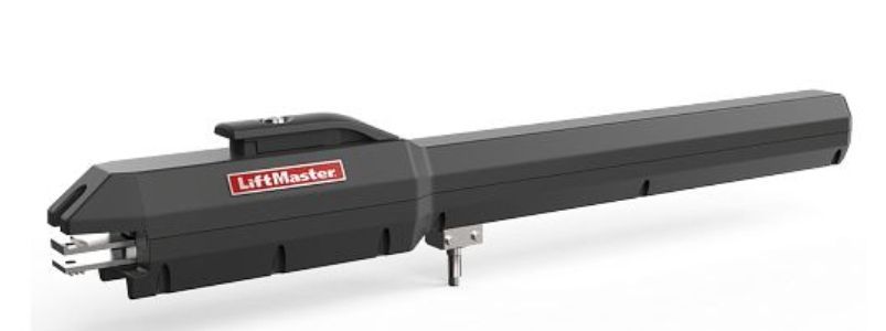 A black garage door opener is sitting on a white surface.