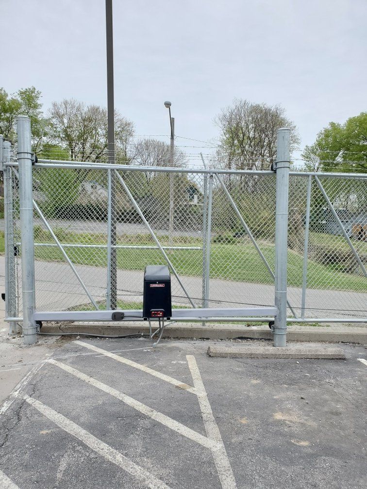 A sliding gate is open in a parking lot