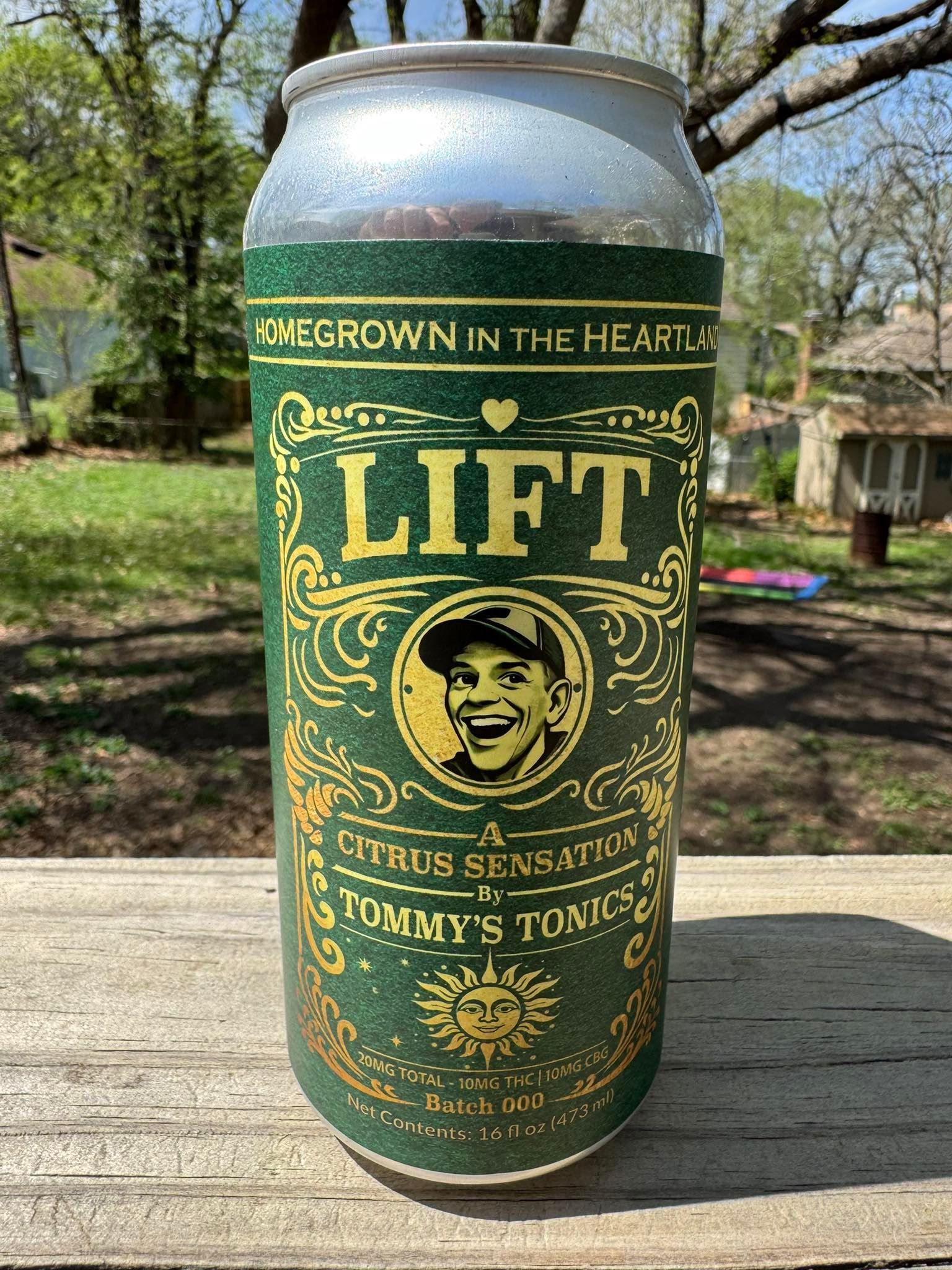 Green LIFT citrus sensation can on a wooden table outdoors with trees in the background