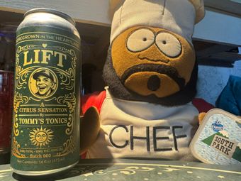 Can of Lift beer beside a South Park Chef plush toy on a shelf