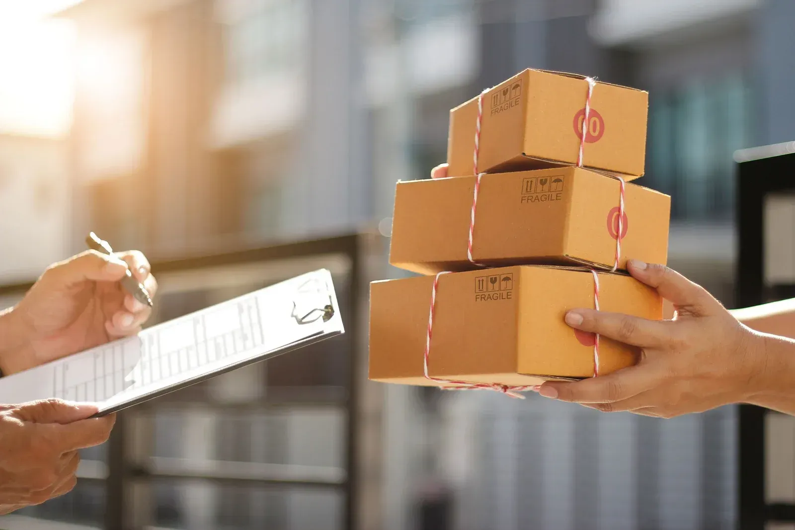 Hands passing a cardboard package beside a pool, with shipping label visible.
