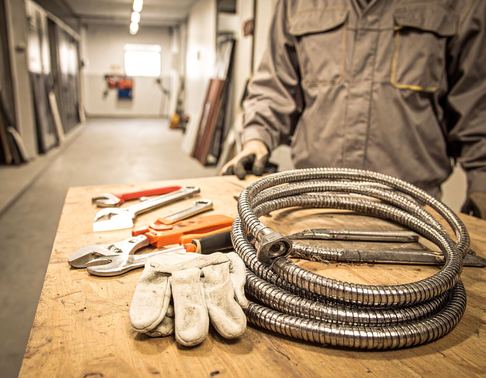 Work gloves, tools, and coiled hoses on a workbench in a workshop