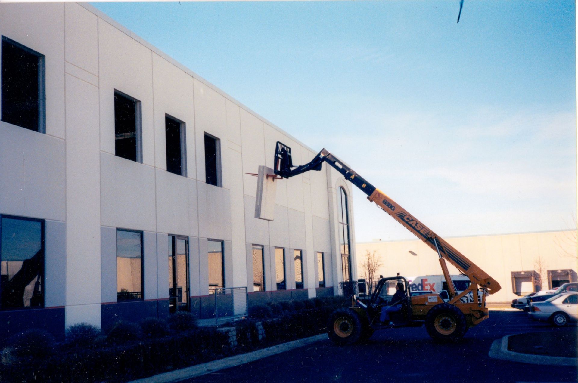 A large building with a yellow forklift in front of it