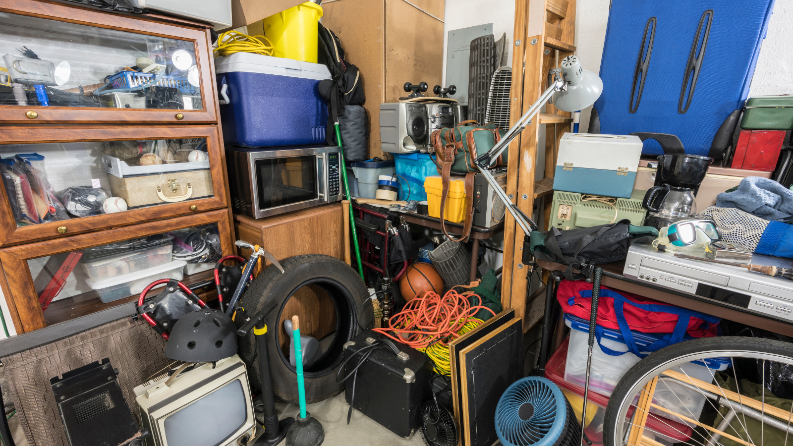A cluttered room filled with lots of junk , including a tire.