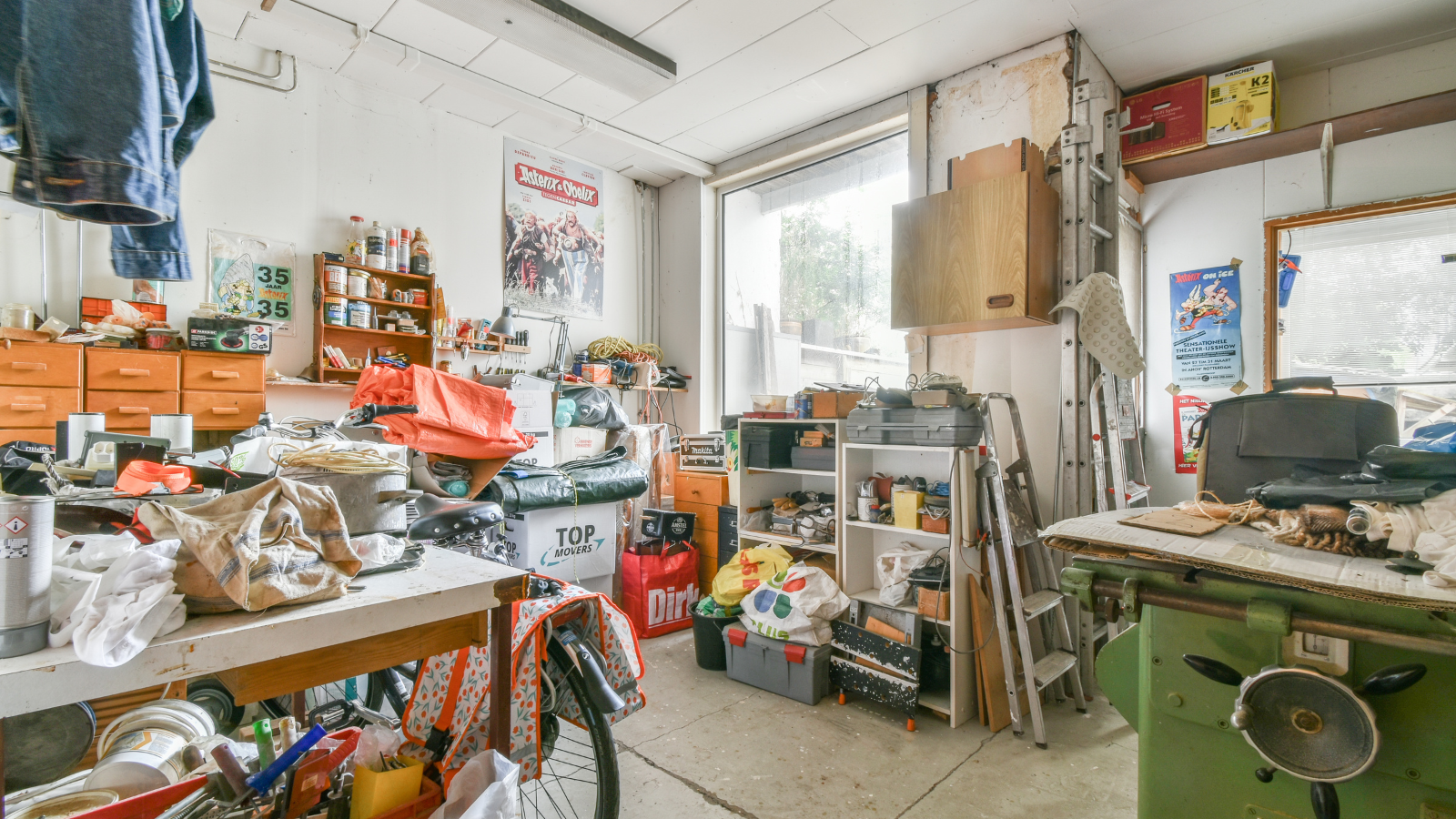 A messy room with a bicycle and a table.