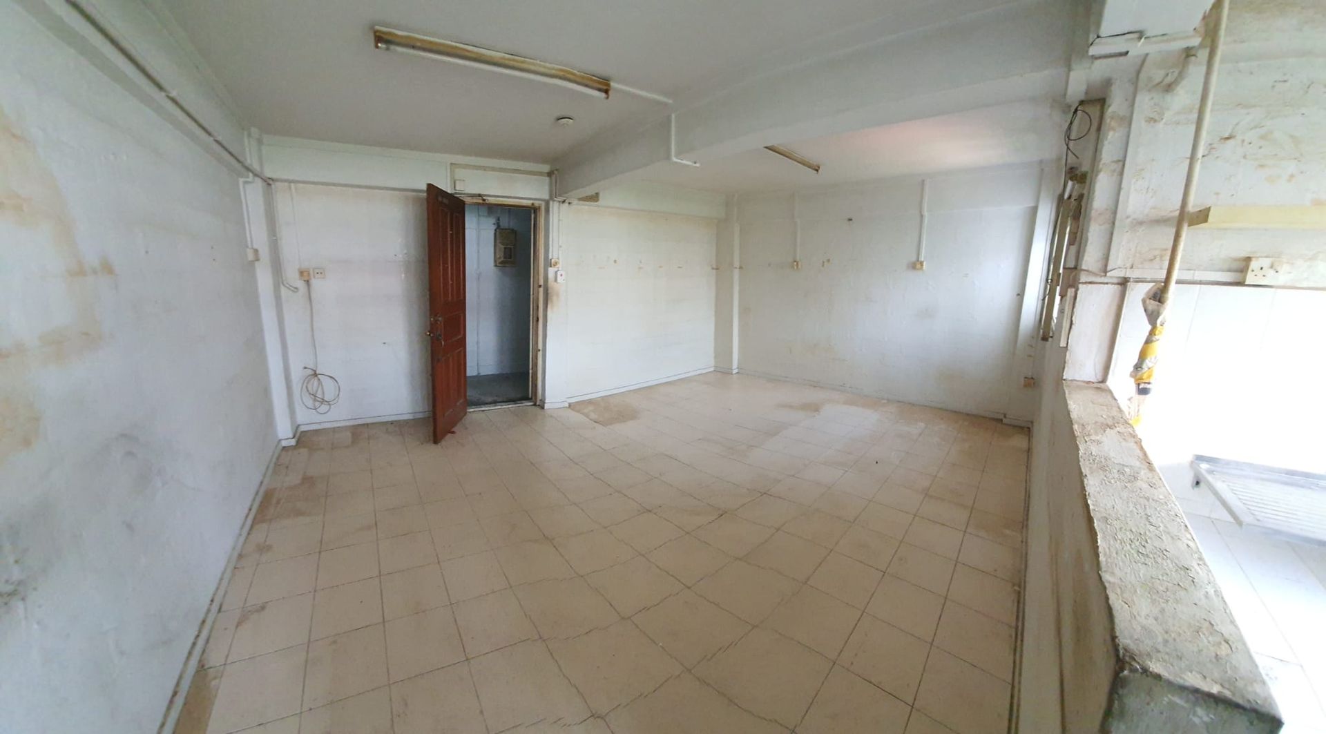 An empty room with a tiled floor and white walls.