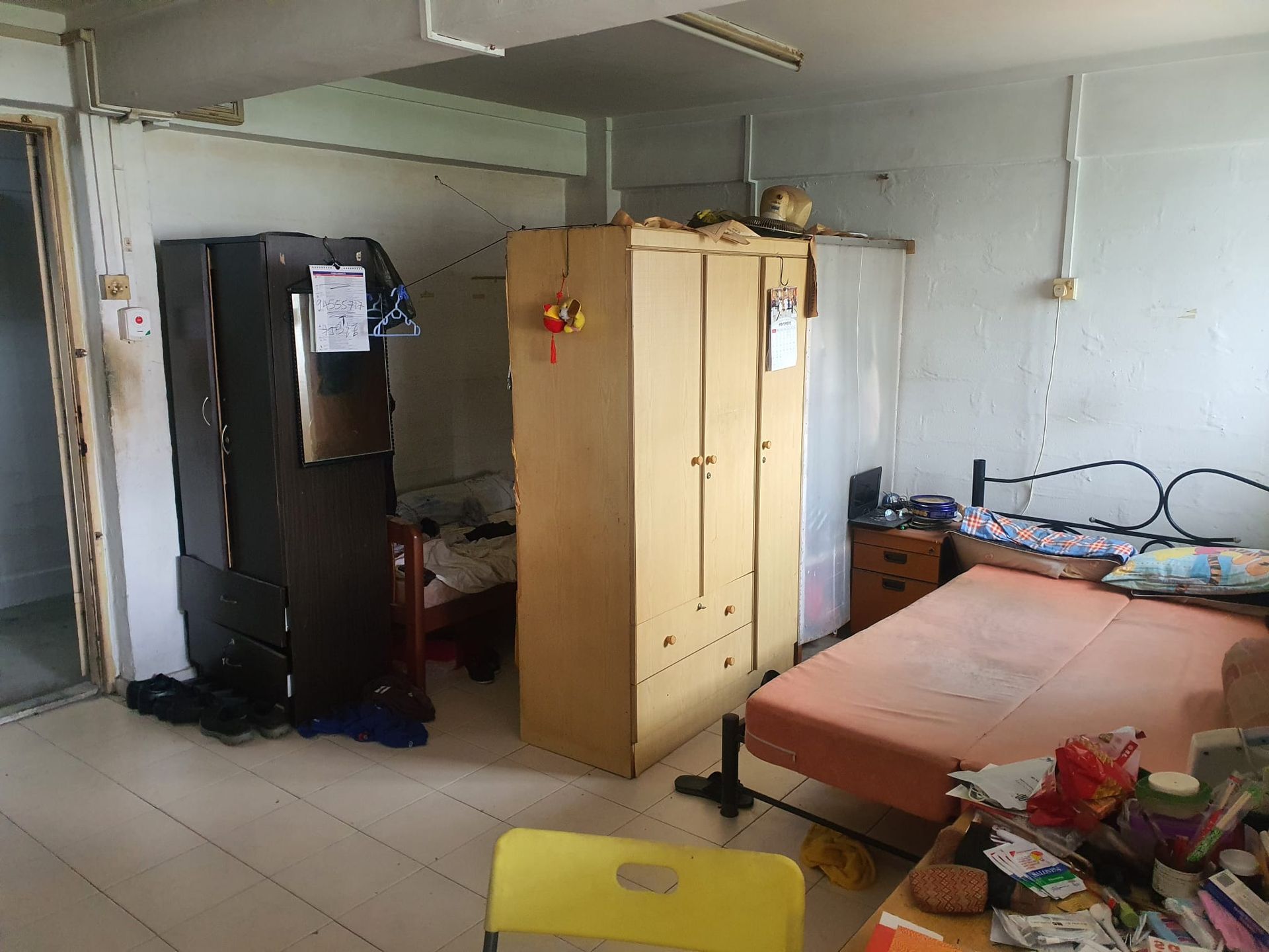 A bedroom with a bed , wardrobe , and chair.