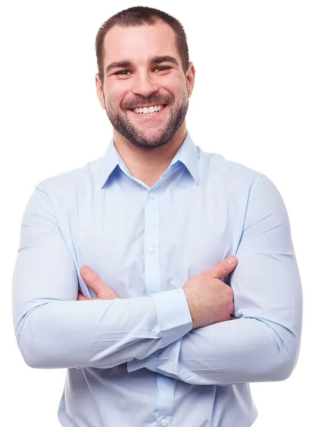 A man in a blue shirt is smiling with his arms crossed