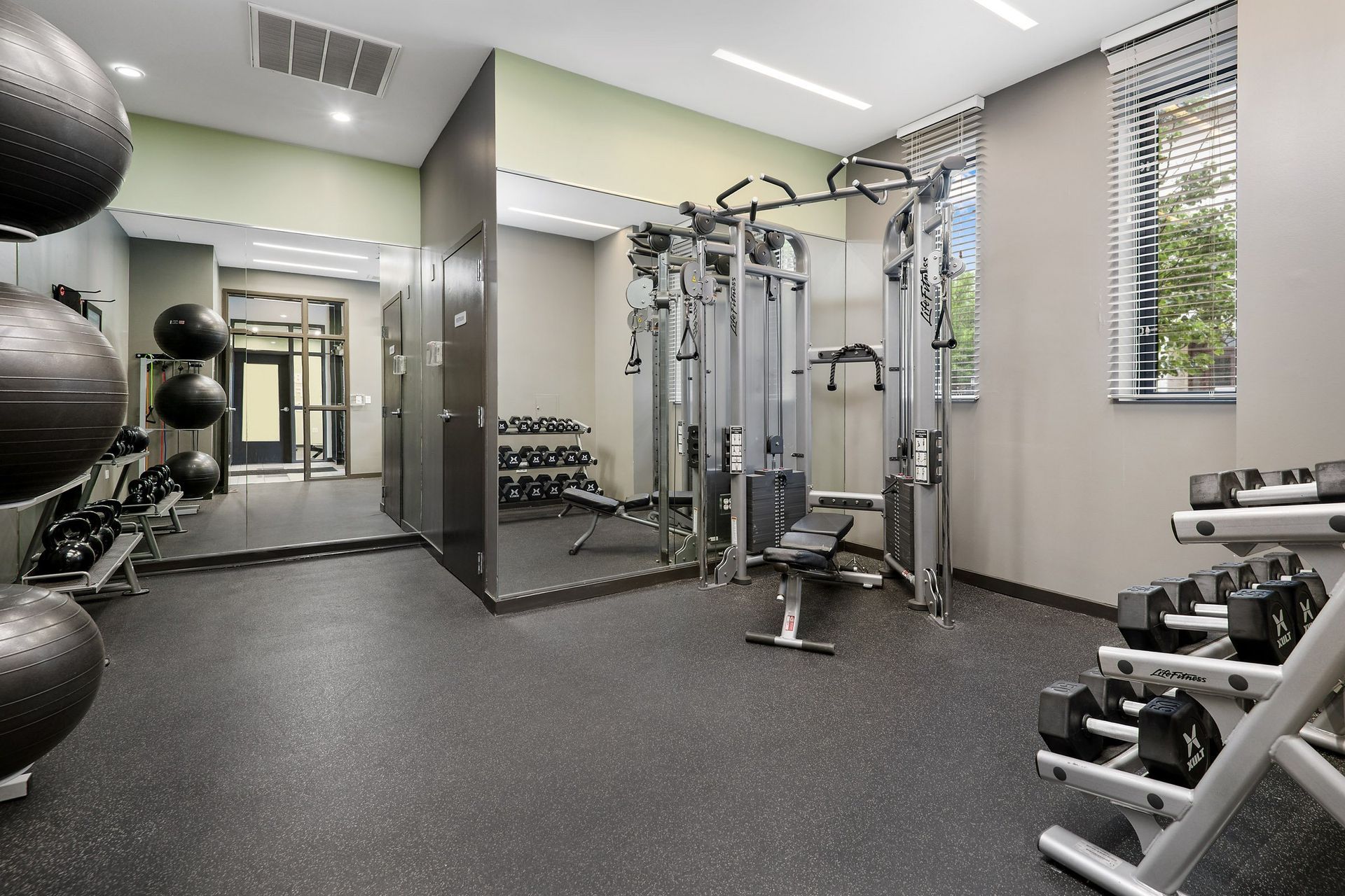 a spacious fitness center with weights machines and mirrors