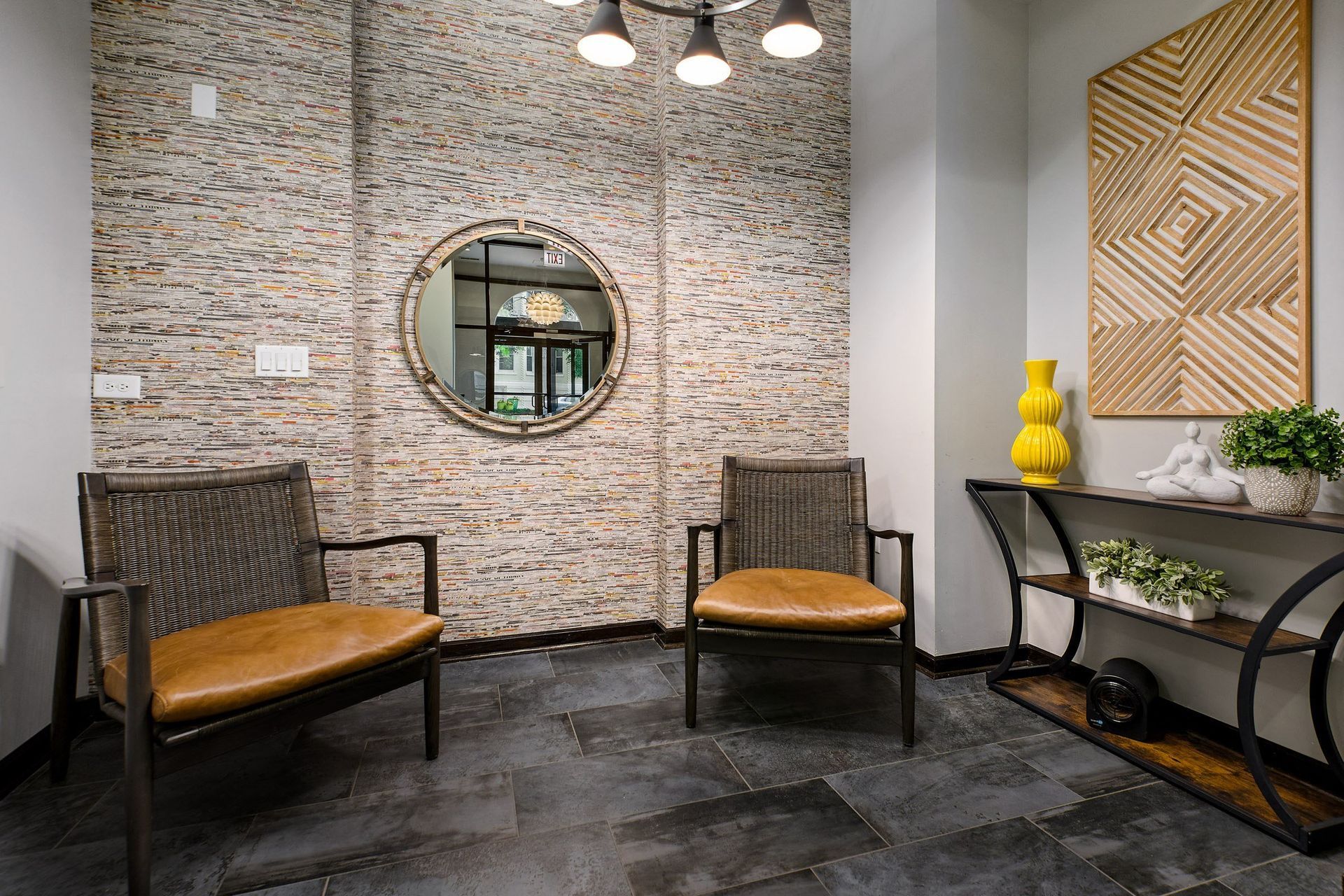 a waiting room with two chairs and a yellow vase
