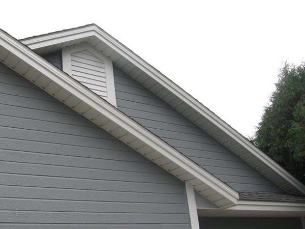 A gray house with a white roof and shutters