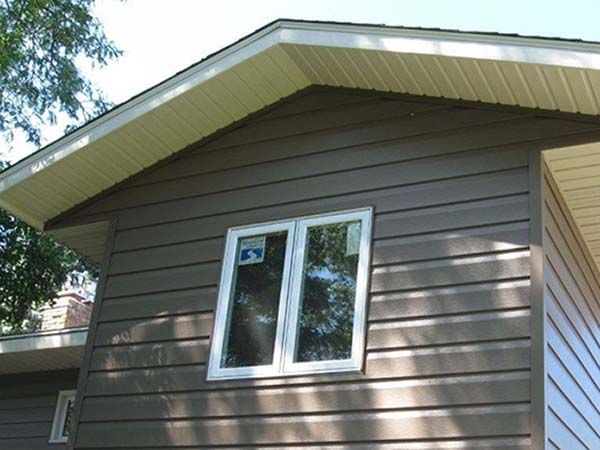A brown house with a white window on the side