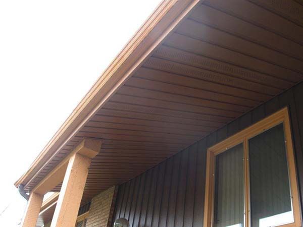 A brown house with a porch and a window