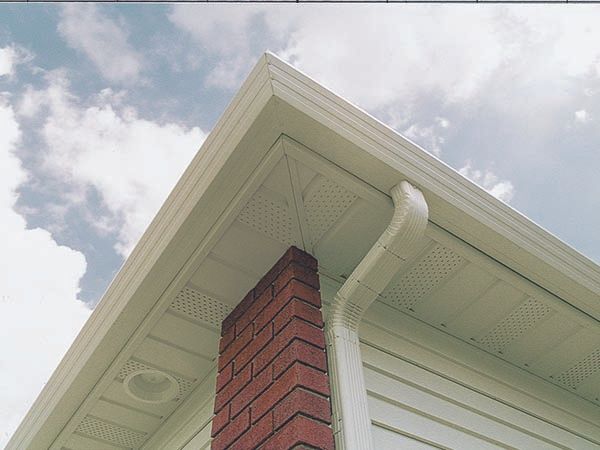 A white house with a brick chimney on the side