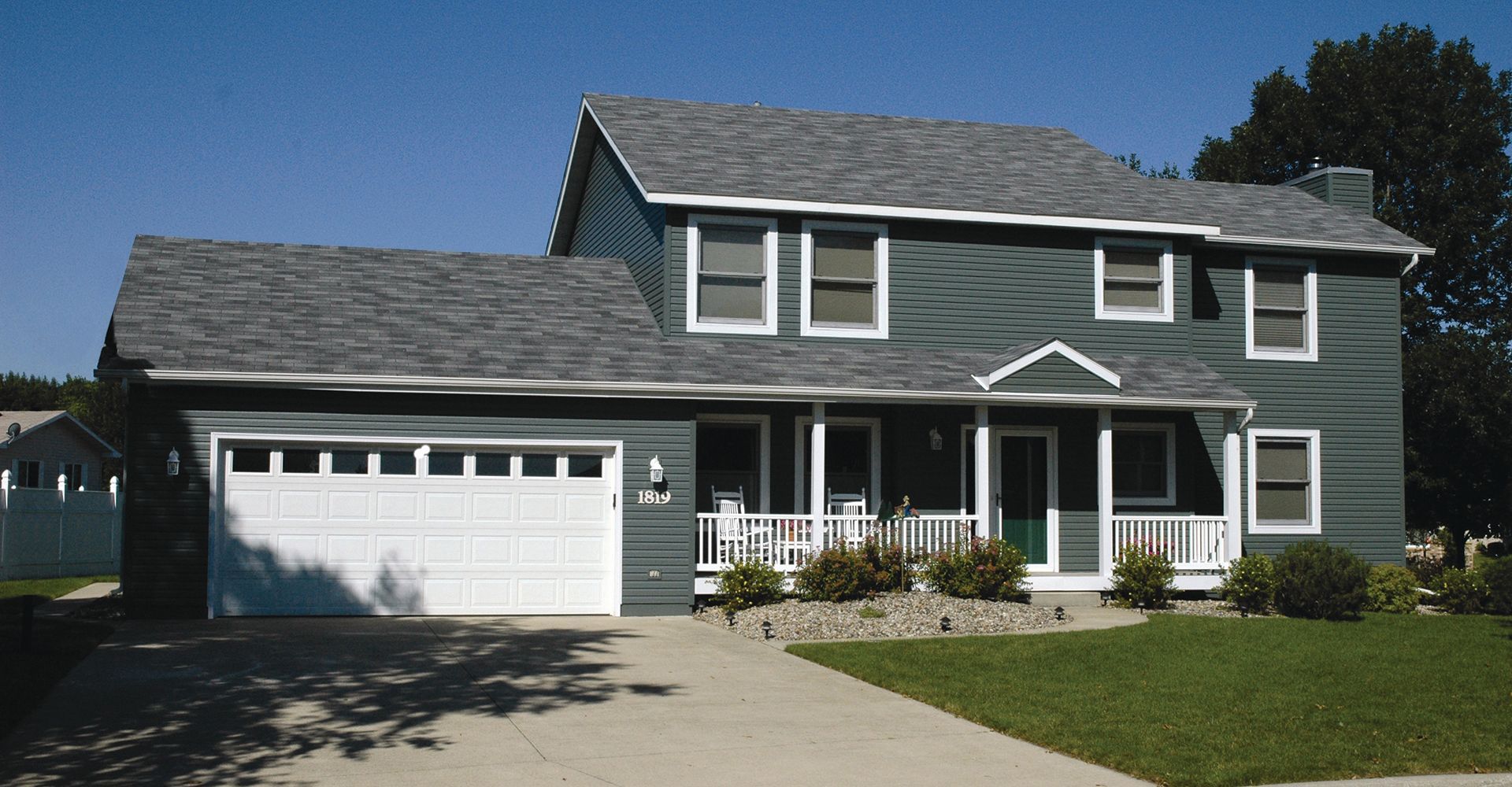 A large house with a gray roof and a white garage door