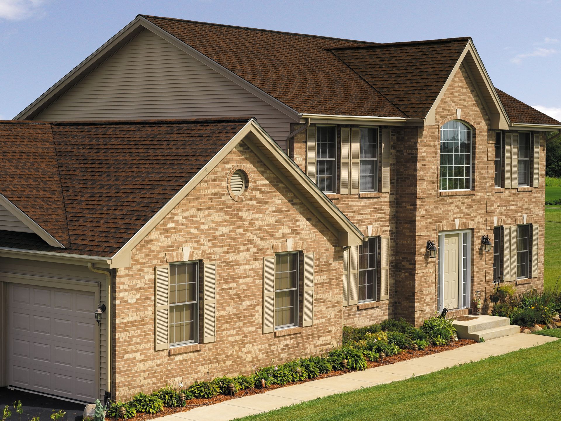 A large brick house with a brown roof