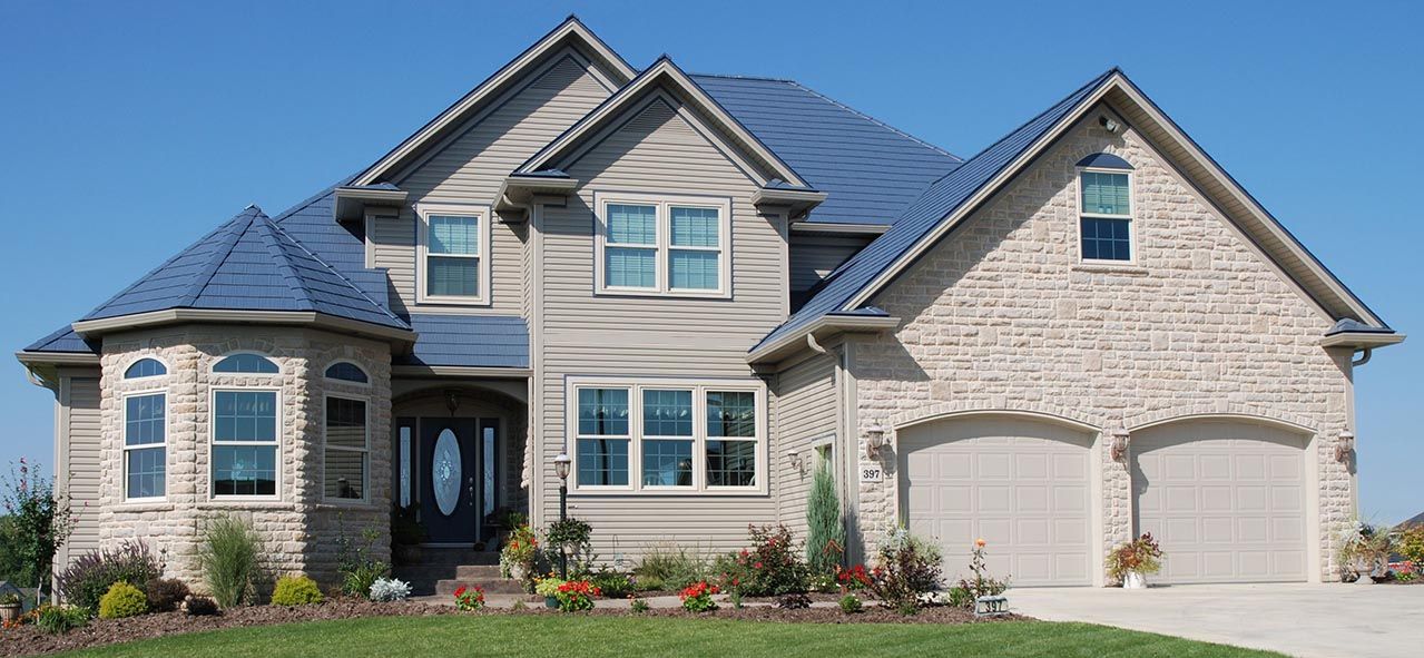A large house with two garages and a blue roof