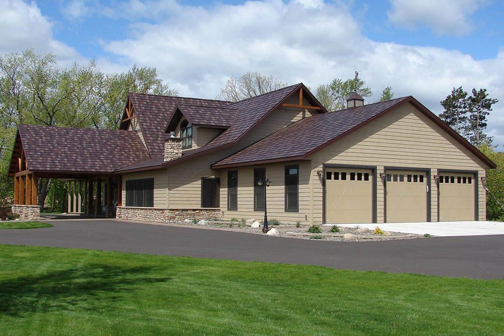 A large house with a purple roof and three garage doors