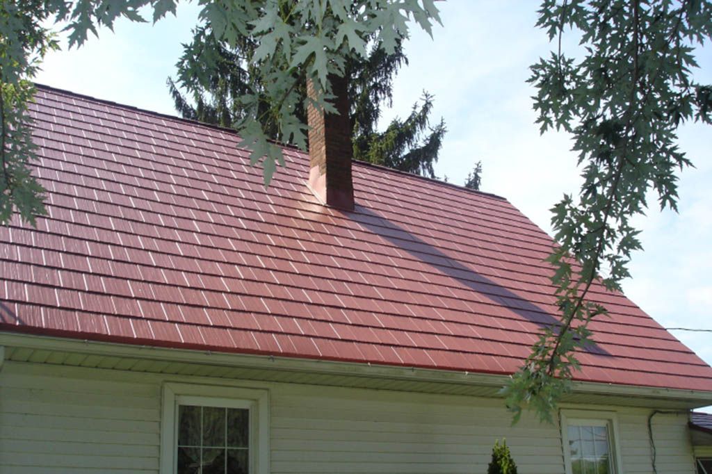 A white house with a red roof and a chimney