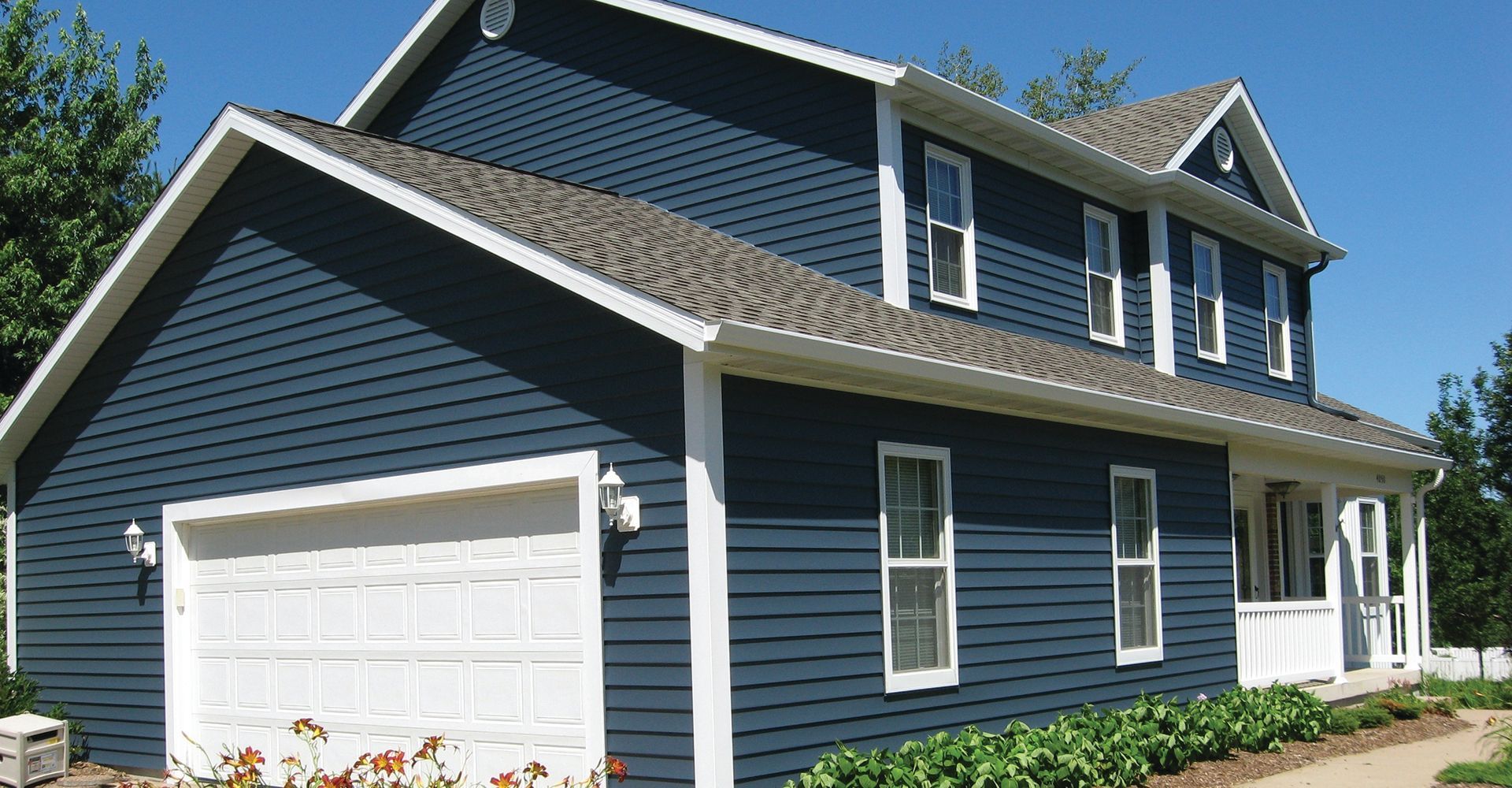 A blue house with white trim and a garage