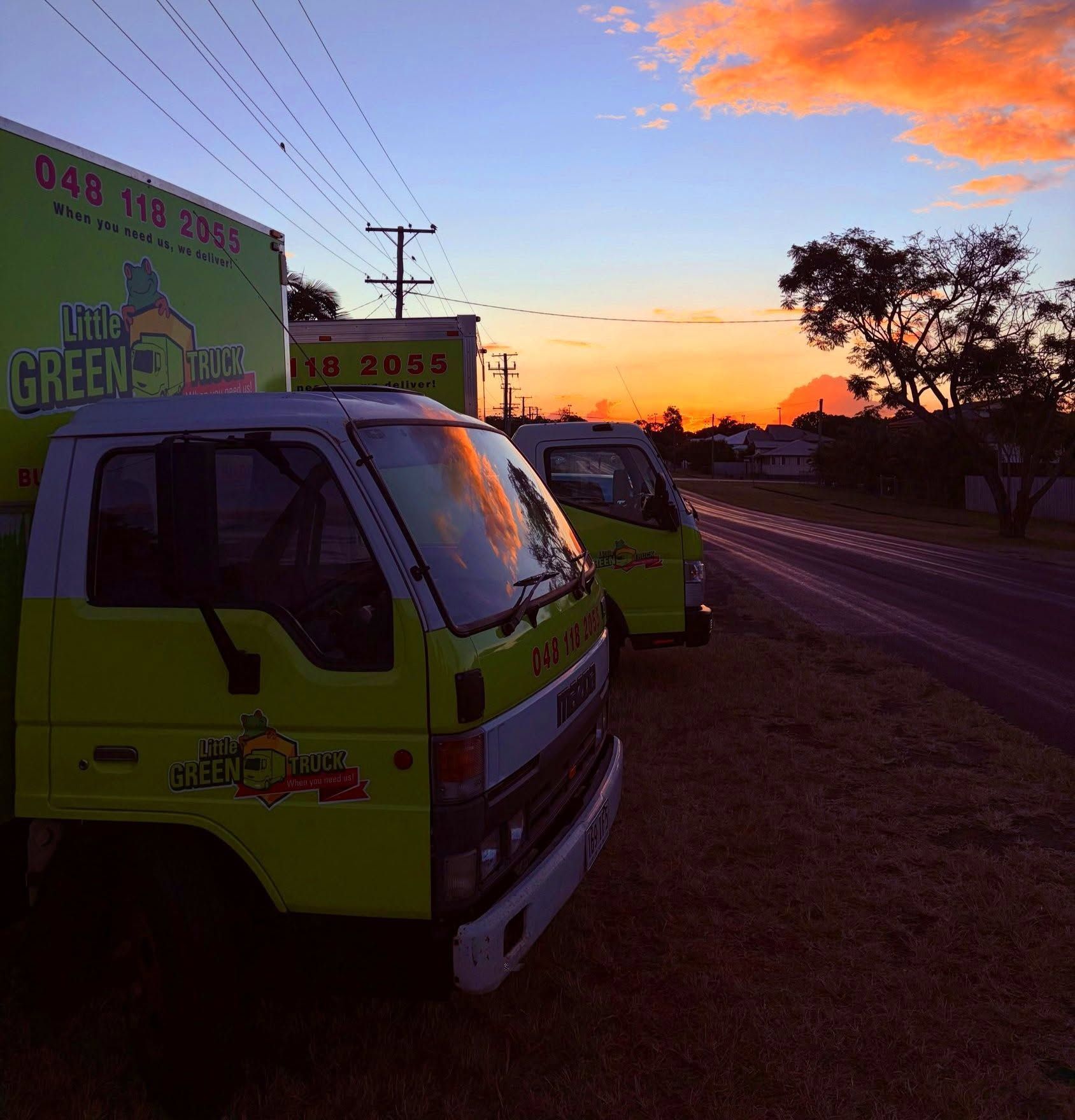 Two Green Trucks Parked Roadside at Sunset with A Colorful Orange Sky — Little Green Truck Bundaberg in Bargara, QLD