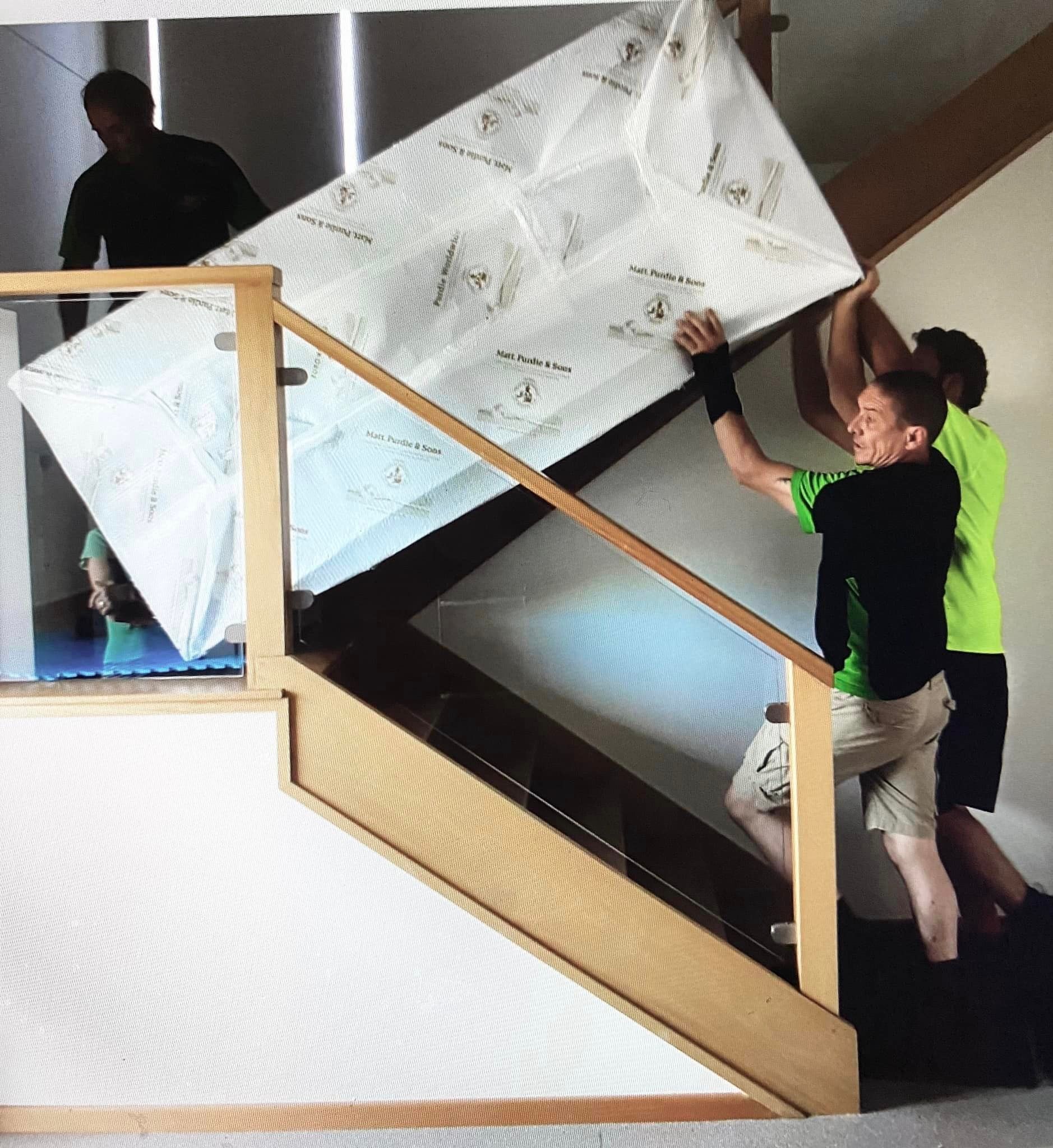 People Carrying a Large Wrapped Mattress Up a Stairwell — Little Green Truck Bundaberg In Moore Park, NSW