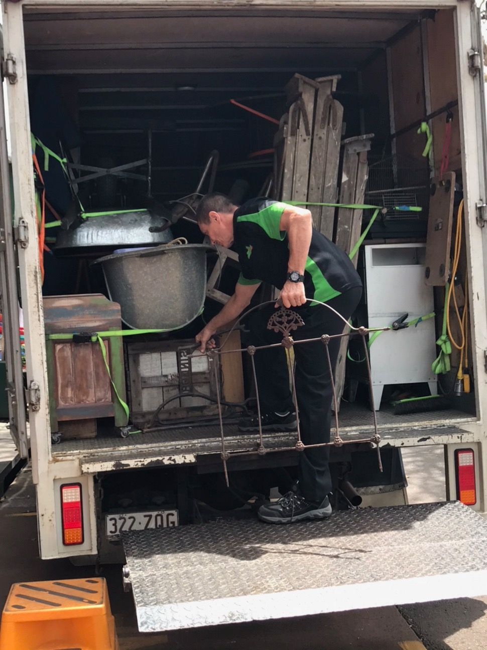 Worker Loading Furniture and Boxes Into a Truck From the Open Rear Door — Little Green Truck Bundaberg In Bargara, QLD