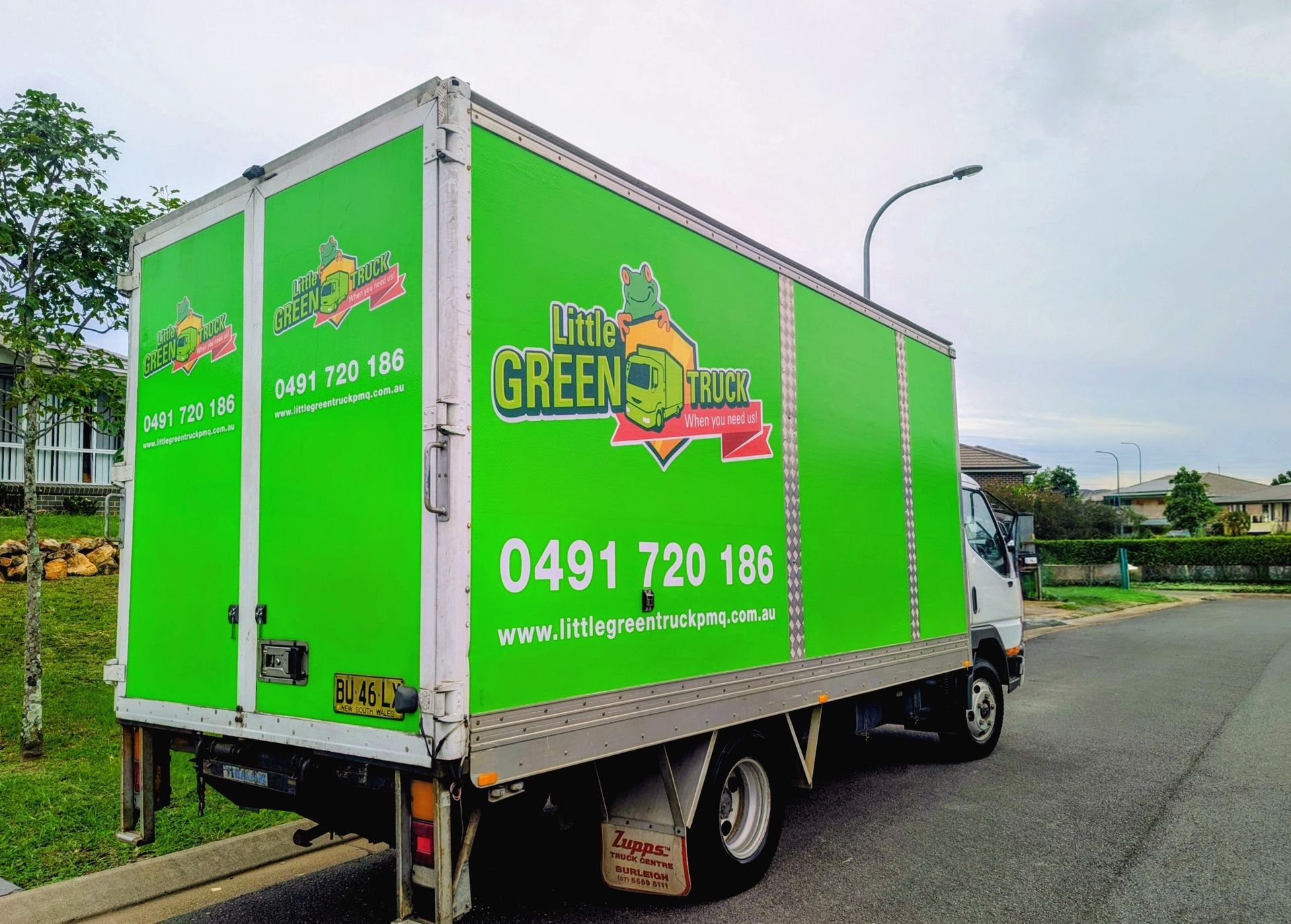 Green Moving Truck with Company Logo Parked on A Residential Street — Little Green Truck Bundaberg in Bundaberg, QLD
