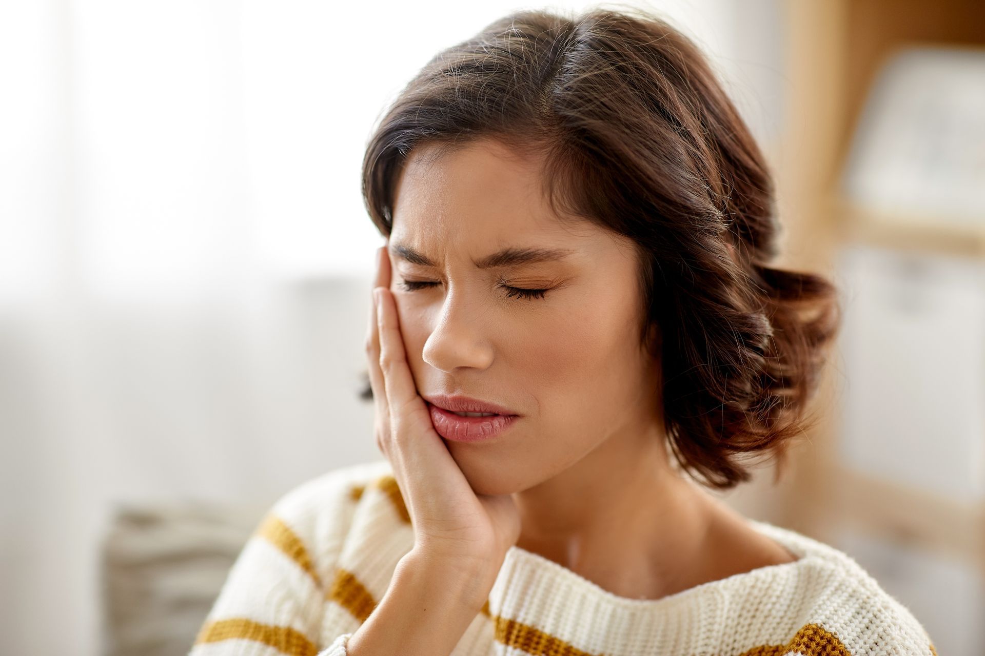 A woman is in pain due to a toothache.