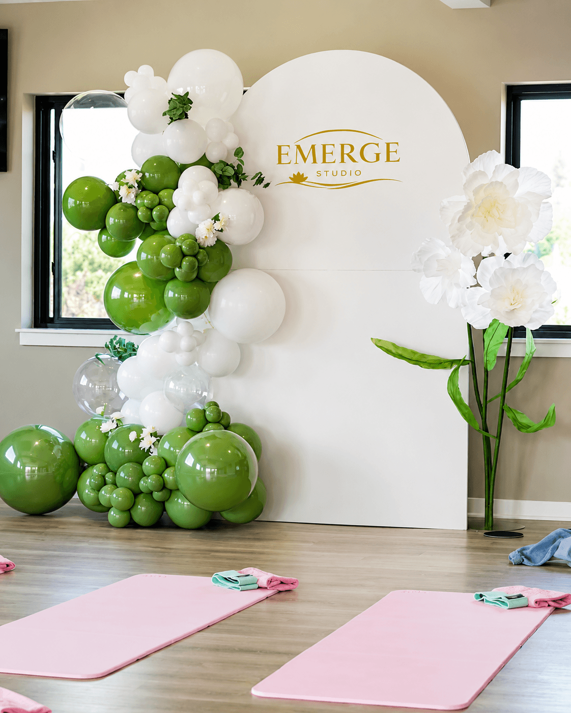 Pilates studio opening ceremony with green and white balloons